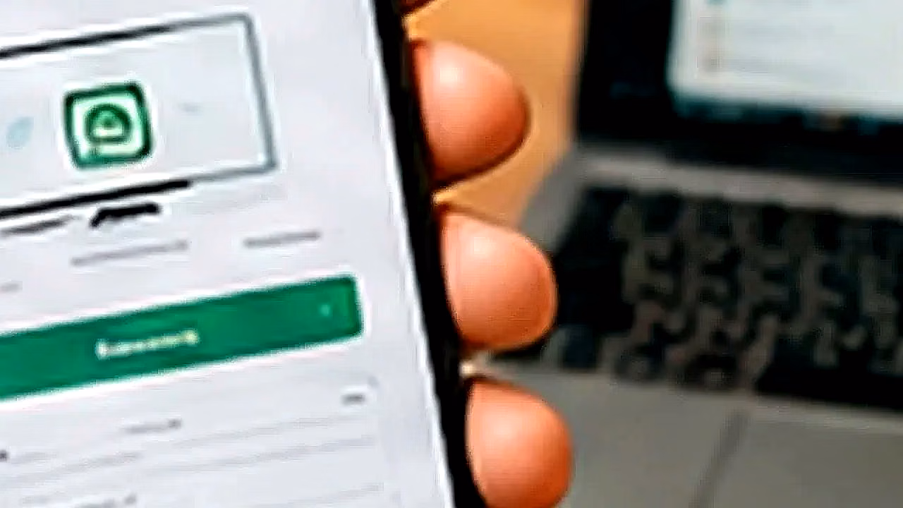 Persona usando WhatsApp Web con laptop y celular en España