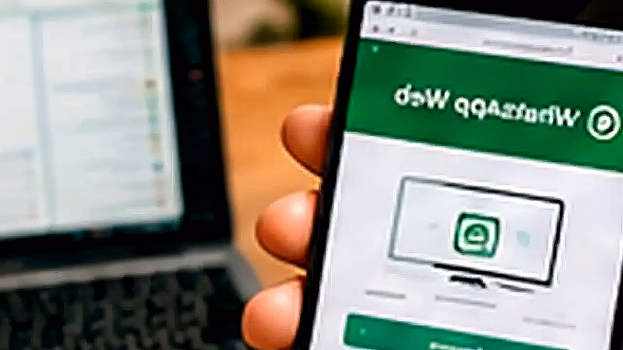 Persona usando WhatsApp Web con laptop y celular en Perú