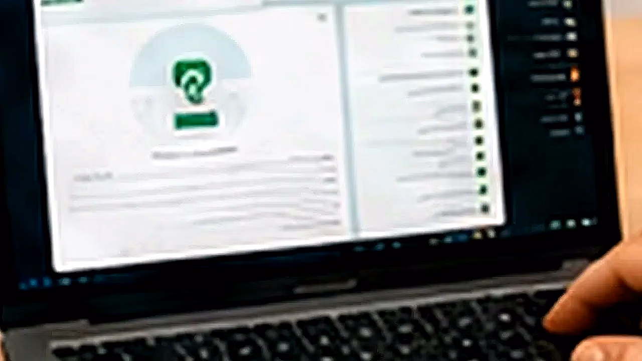 Persona usando WhatsApp Web con laptop y celular en Perú