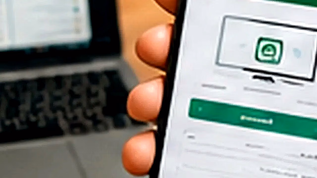Persona usando WhatsApp Web con laptop y celular en Perú