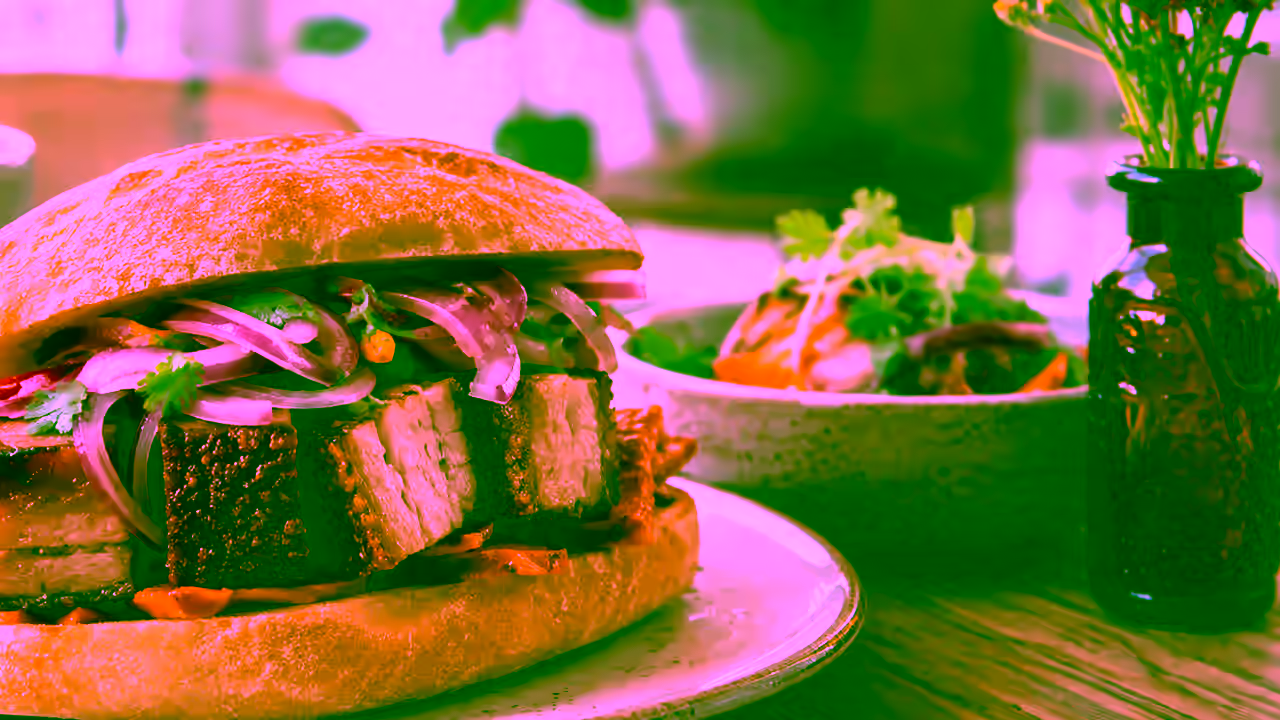 Detalle de un pan con chicharrón peruano servido al estilo tradicional